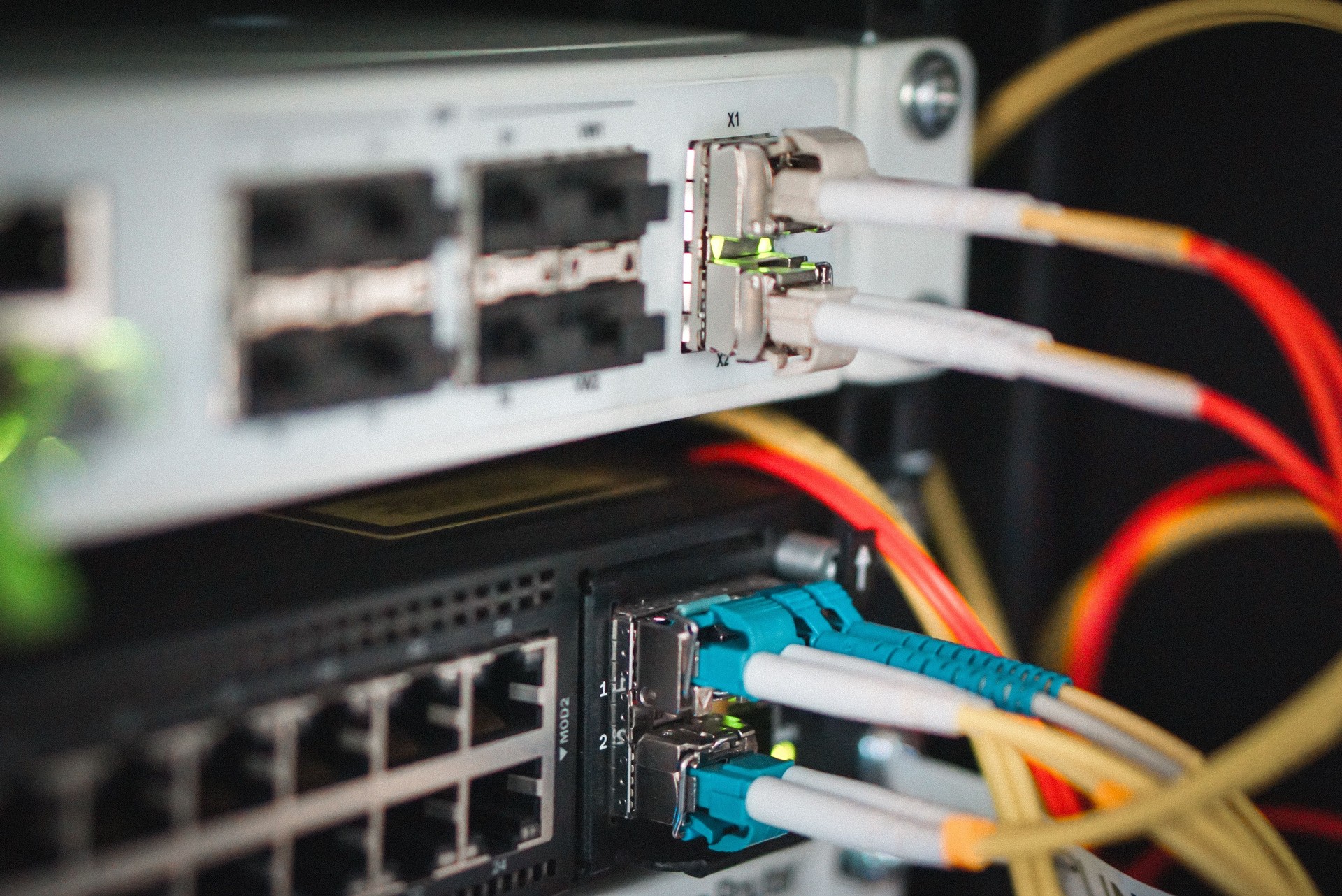 Optical gigabit sfp transceiver modules on networking switch in data center room with fiber optic cables connected